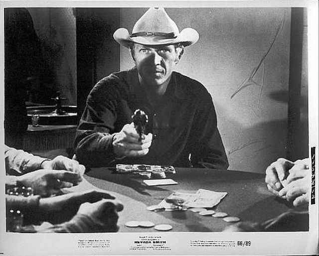 Max (McQueen) draws gun at card table.